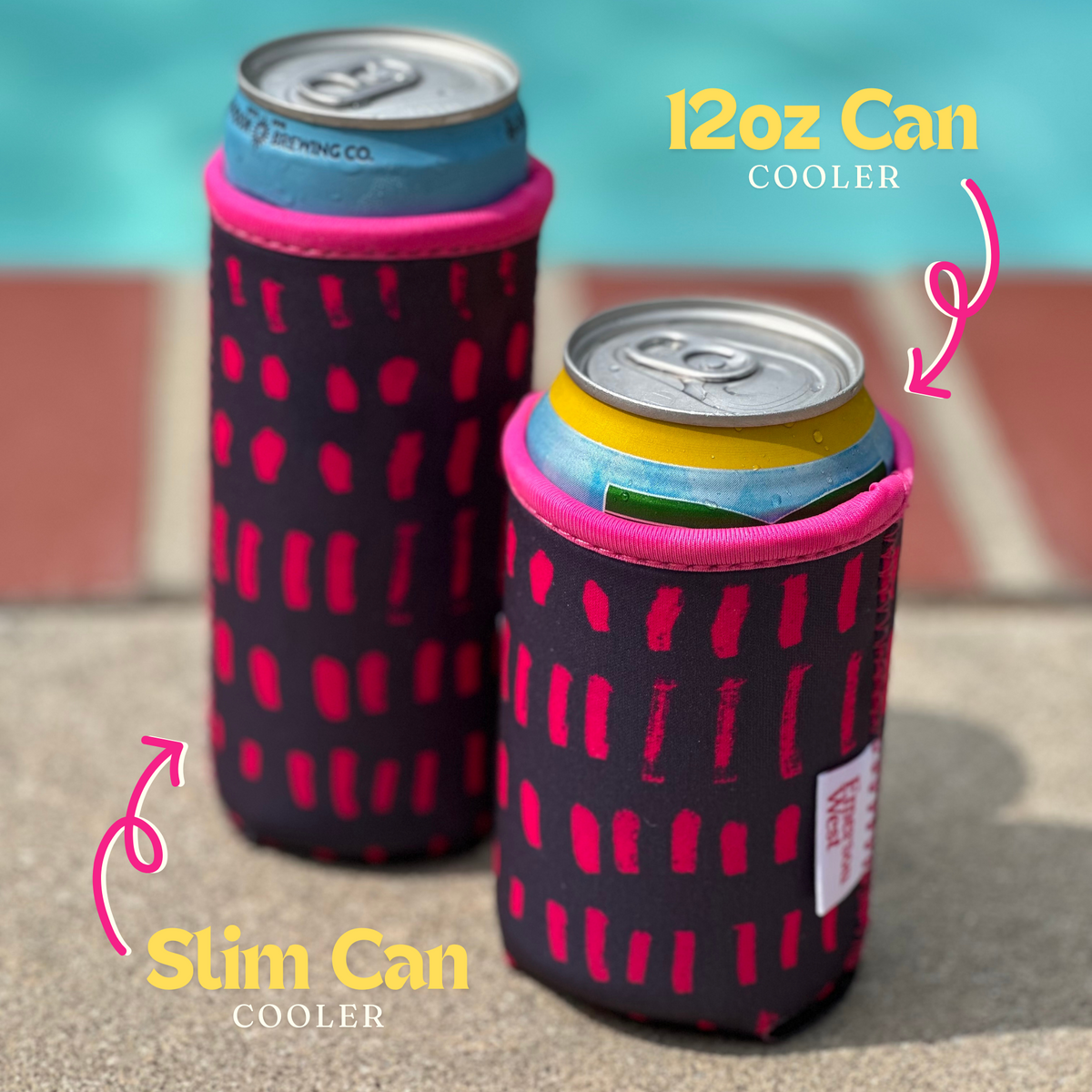 The image shows two Navy & Pink Neoprene Can Coolers by Emerson West by a pool, each in a black neoprene can cooler with pink cheetah patterns. One cooler is labeled for a 12oz can, and the other for a slim can. Both coolers appear designed to keep drinks cold on a sunny day, perfect for poolside relaxation.