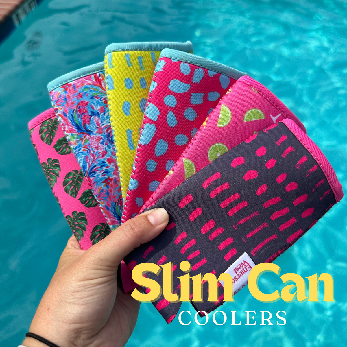 A hand fan displaying five patterned neoprene can coolers with designs including monstera leaves, tropical fruits, and abstract shapes. The background shows a swimming pool while text reads "Palm Leaves Neoprene Can Coolers by Emerson West.