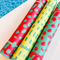 Colorful Oh So Bright Collection swimming pool mats with fun patterns resting poolside - ready for some splashing good times. (Emerson West)