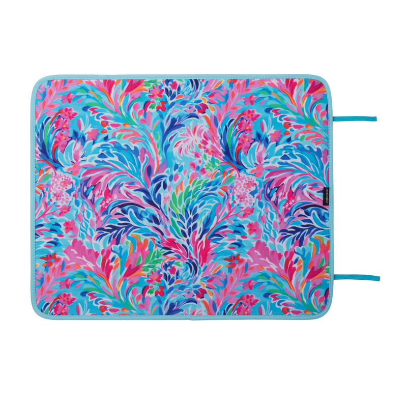 A rectangular, multi-colored Resort Blooms Poolside Seating Mat by Emerson West featuring an intricate, vibrant floral design with shades of pink, blue, purple, and green. The fade-resistant mat has light blue borders with turquoise ties on the right side, making it visually striking and colorful.