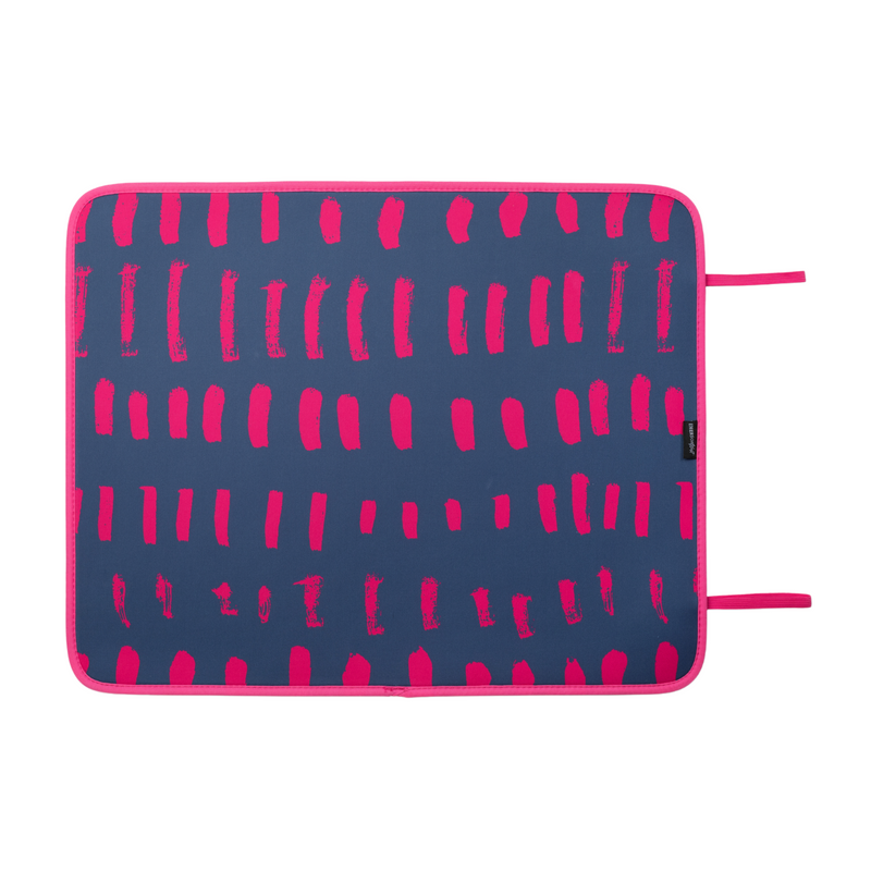 The Emerson West Navy & Pink Poolside Seating Mat with a matte finish features a navy blue background and a pattern of irregular vertical pink lines. The quick-dry mat has pink edges and two pink fabric loops on the right side, ensuring both style and practicality for outdoor use.